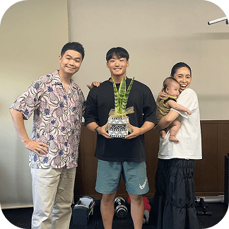 利用者とその家族がジム内で記念写真を撮っている様子