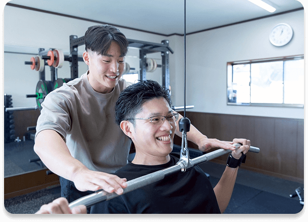 トレーナーが初心者の利用者に丁寧にサポートしている様子